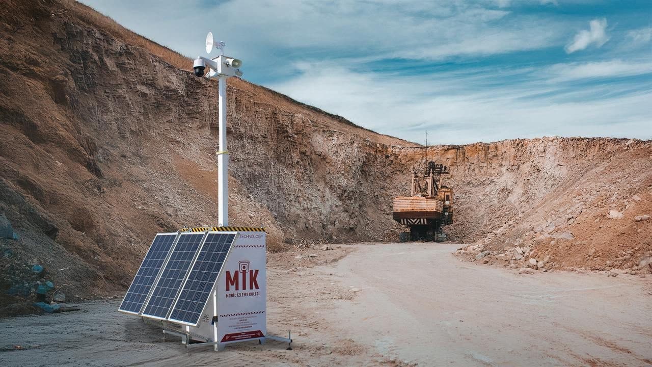 Açık ocak sahasında kurulu Mobil İzleme Kulesi ve arkasında iş makinesi
